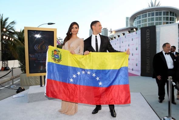 Los dos conductores se presentaron en la alfombra con una bandera de Venezuela y se la mostraron a quienes pasaban,
