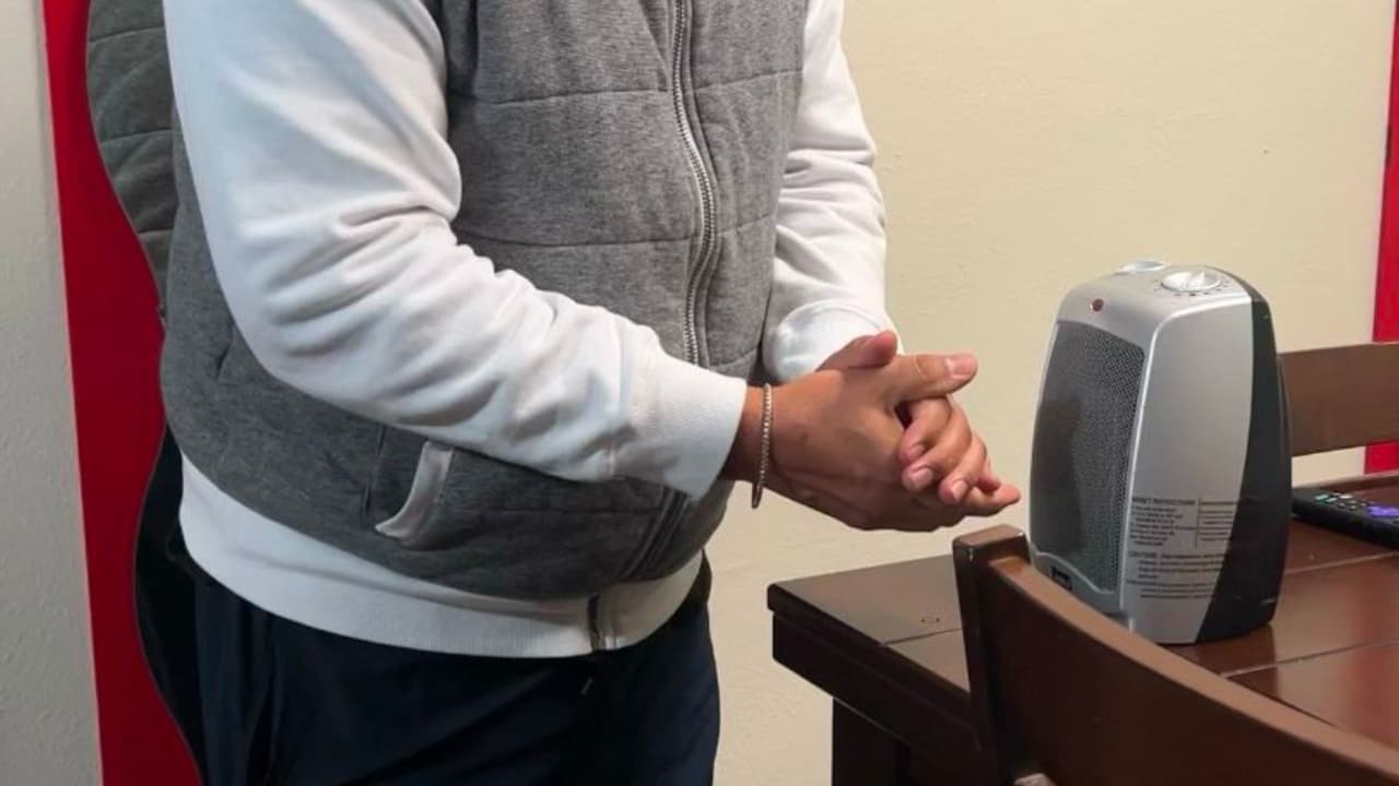 Vemos las manos de Salvador mientras busca calentarse en medio de las temperaturas heladas, con ayuda de un pequeño dispositivo.