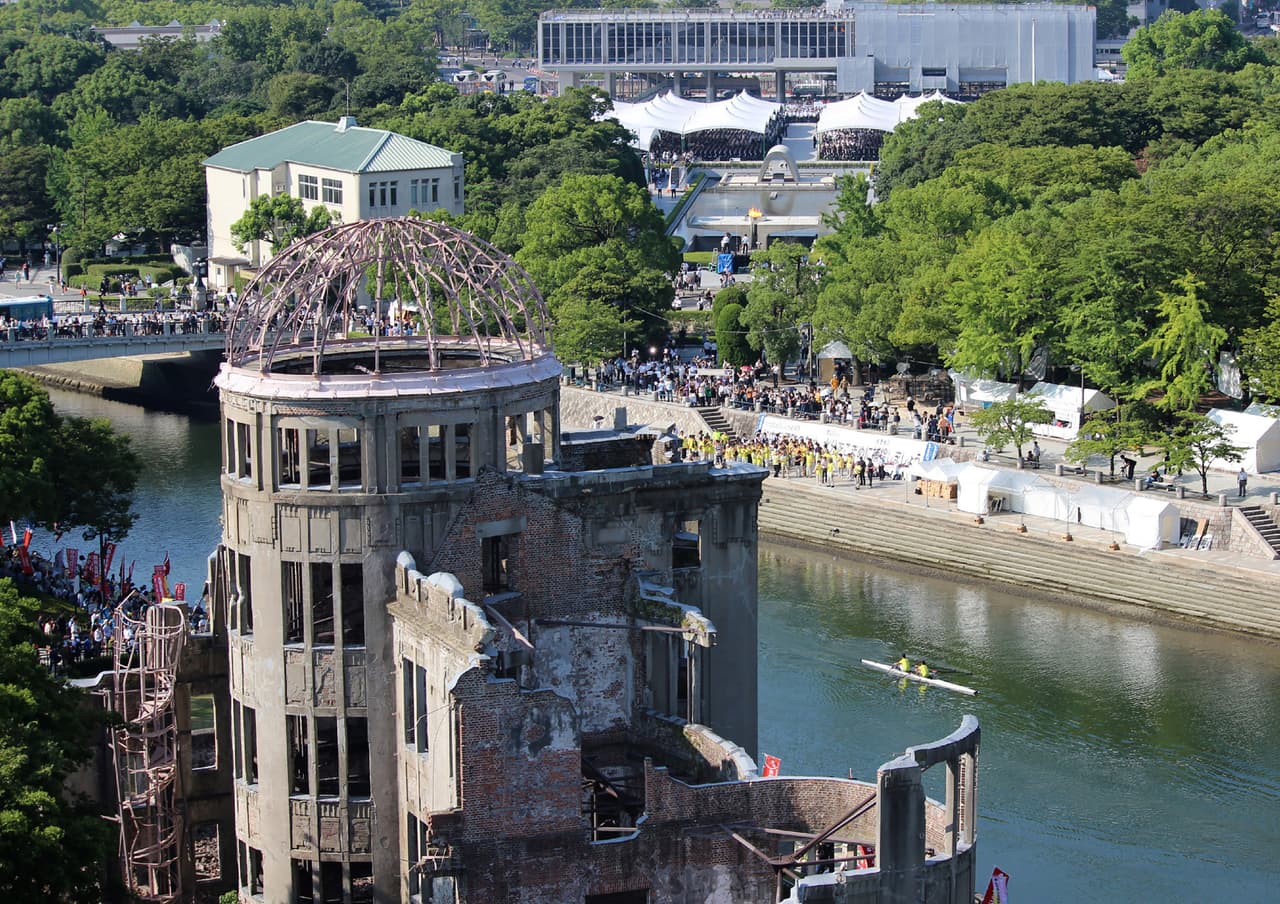 El 'Domo de la Bomba Atómica' en primer plano y los asistentes a las actividades conmemorativas de 2018 en Hiroshima.
<br>
<br>Este edificio en ruinas se mantuvo en pie para recordar las consecuencias de la guerra.