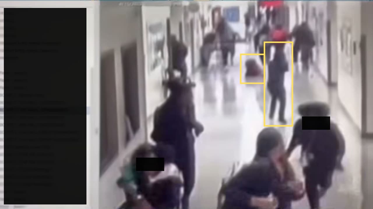 Los alumnos huyen del lugar, cuando
<b>uno de ellos cae al suelo</b>, a solo unos pasos del joven con capucha, que
<b>continúa apuntando al grupo.</b>