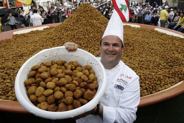El Chef libanés Ramzi Choueiry sostiene un cubo de bolas de falafel frito antes de añadir a un plato grande, en un intento de establecer un nuevo récord mundial Guinness en Beirut el 9 de mayo de 2010.