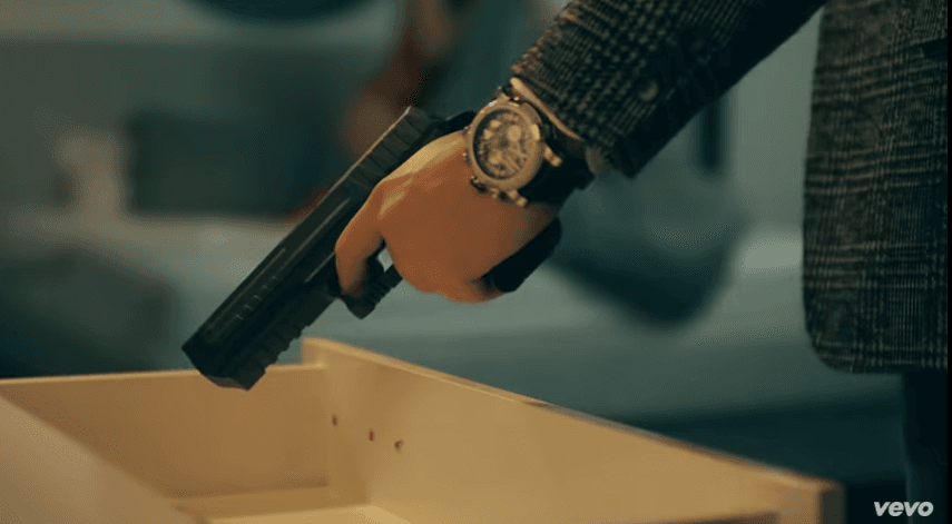 El hombre cegado por los celos, toma un arma y le apunta al amante de su mujer.