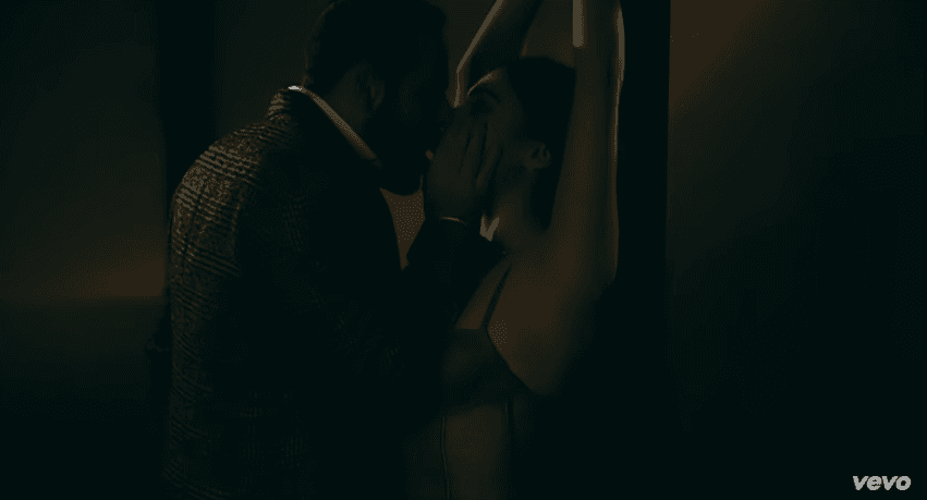 Amarrada de una columna, la besa por última vez y la conduce hasta la parte trasera de su auto.