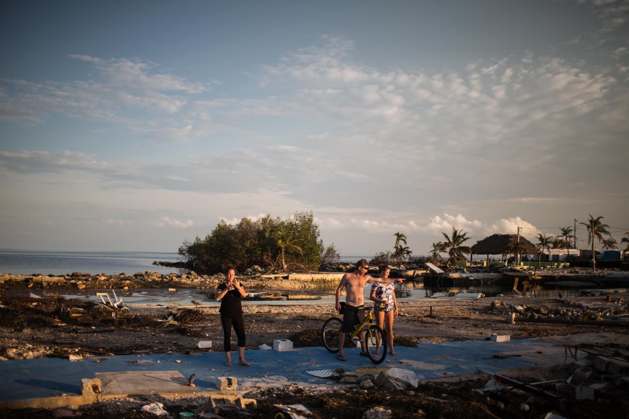 Billy 'the kid' Queen, 48 años, le señala a la hija de una vecina de Plantation Key dónde estaba su dormitorio en el tráiler sobre el que se encuentra que el huracán Irma despedazó completamente. El abuelo de Billy compró el tráiler hace décadas y él ha vivido aquí desde que tiene 20 años. Es carpintero. "Los trabajadores de toda la gente rica vivimos en viviendas de bajos recursos como estas", dice Billy. "A cuánto te has enfrentado en la vida es lo que te hace soportar cosas así. Estoy acostumbrado a hundirme y tener que volver a levantarme". Almudena Toral/Univision Digital