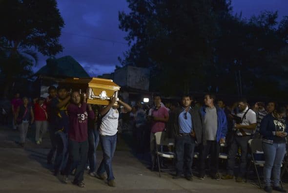 Amigos y familiares de Julio César llevan el ataúd por los pasillos de la escuela de Ayotzinapa donde estudiaba el joven.