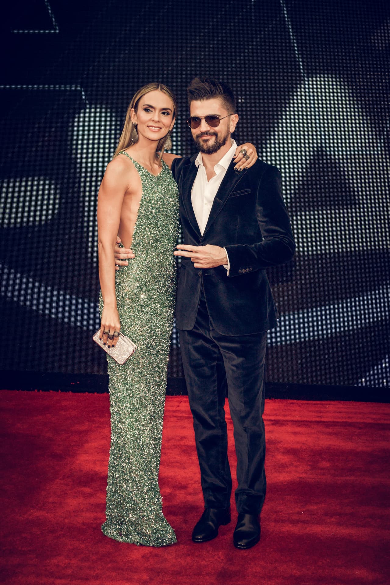 La pareja formada por Juanes y Karen Martínez también se destacó en la alfombra roja: él, con un traje de terciopelo; y ella, con un vestido largo verde bordado de escote redondo y corte profundo 'sideboob'.