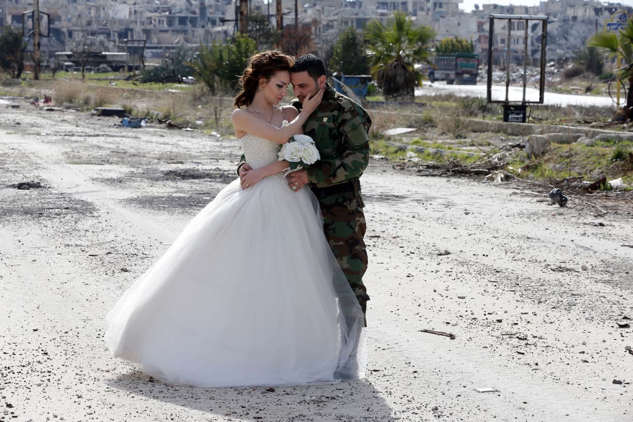 Los recién casados, Nada Merhi (18 años) , y el soldado del ejército sirio Hassan Youssef (de 27 años) en una calle de la devastada ciudad siria de Homs.