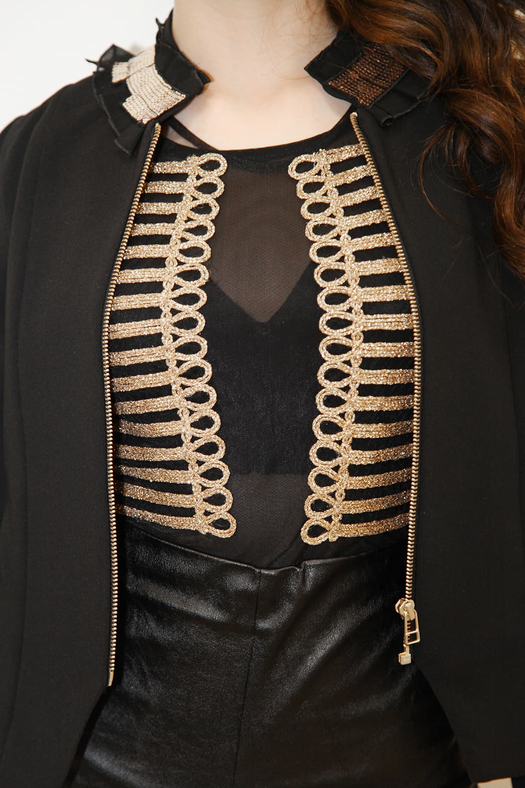 Además del top de gasa negra, que tenía aplicaciones doradas (parecidos a los de una chaqueta militar), combinó perfectamente con una chaqueta de cuello alto.
