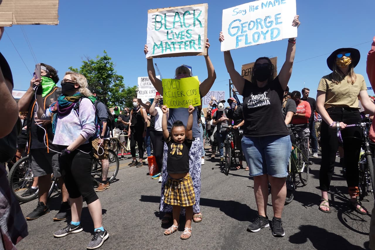 Una pequeña levanta un cartel durante la manifestación en Minneapolis este sábado. "Black Lives Matter", el movimiento surgido a raíz de la violencia en contra de los afroestadounidenses, y "Pronuncia mi nombre: George Floyd", se lee en las pancartas.