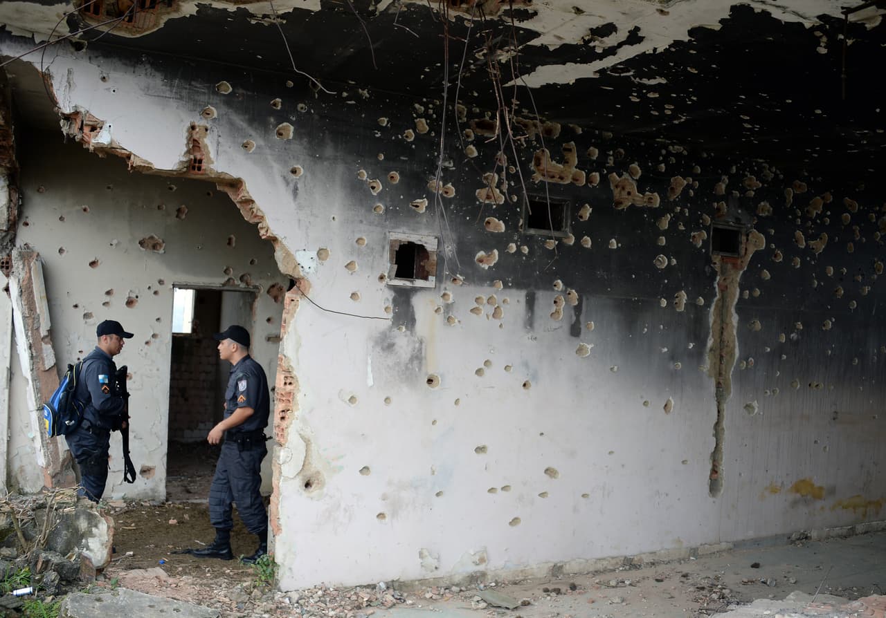 Brazilian militarized policemen search a place that allegedly belonged to a drug-trafficker, at the Mangueirinhas favelas complex, in Duque de Caxias, 30 km from Rio de Janeiro downtown, on August 5, 2013. The complex, located in the Baixada Fluminense, is currently controlled by a drug-traffickers gang faction known as "Comando Vermelho" (Red Command) to which many drug-traffickers from pacified favelas have migrated in the last years. AFP PHOTO / VANDERLEI ALMEIDA (Photo credit should read VANDERLEI ALMEIDA/AFP/Getty Images)