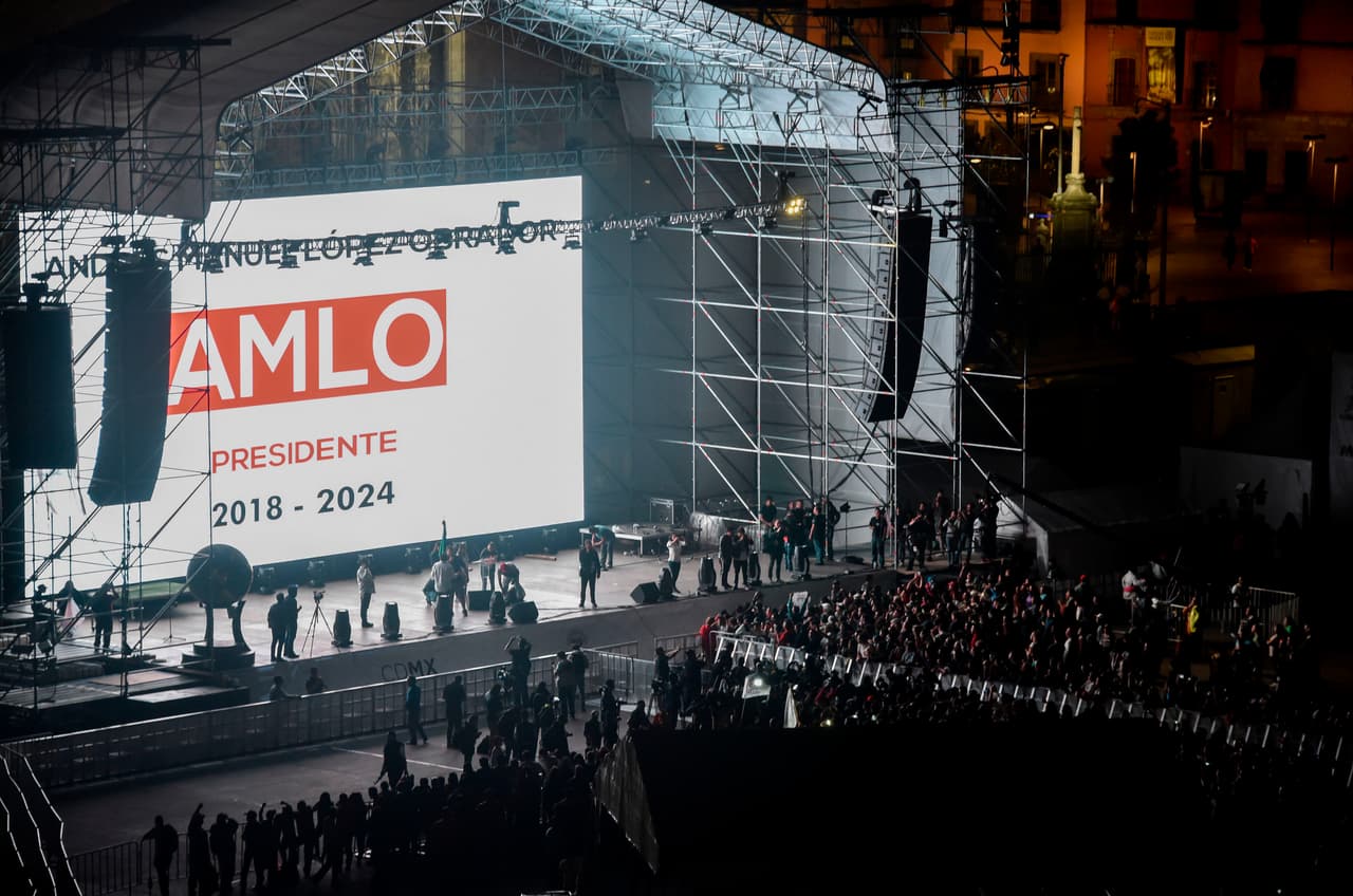En una pantalla colocada en la tarima del Zócalo se puede leer: “AMLO presidente”.