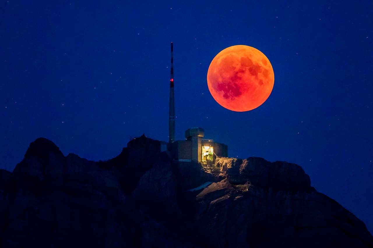 La Luna de sangre se eleva detrás del pico Santis, de 8,202 pies de altura, en Alpstein, Cantón de Appenzell, Suiza.