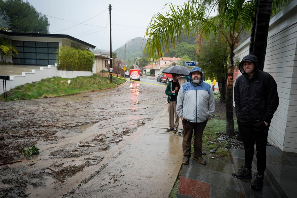 A cierta distancia, algunos vecinos se mantenían pendientes a que no bajara más fango y piedras de las montañas.