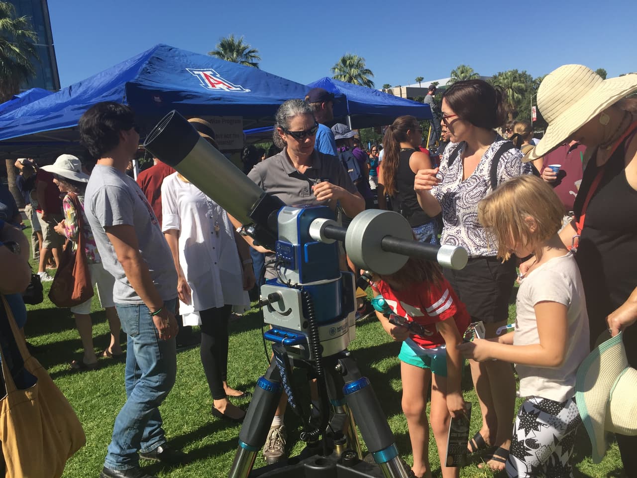 Niños y adultos hacen fila para tener acceso a los telescopios.