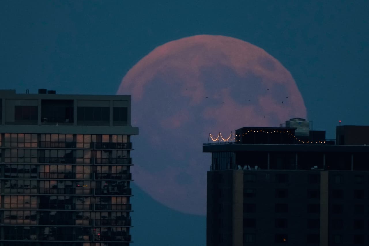 La luna llena se eleva sobre los edificios de apartamentos en el centro de Kansas City, Missouri, antes de un eclipse lunar el jueves 27 de agosto de 2026.