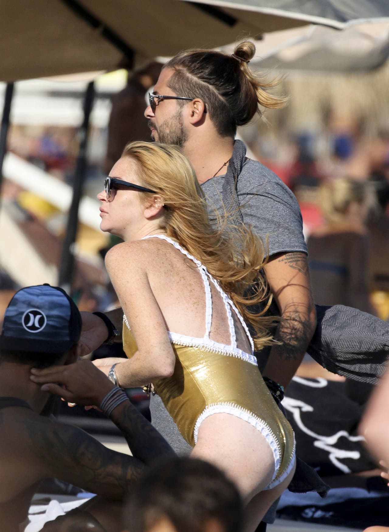 Lindsay usó un traje de baño dorado para su visita a la playa.