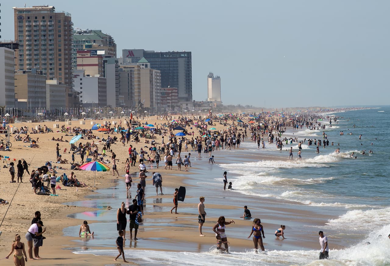 Una multitud disfruta de un día de sol en una playa de Virginia Beach, Virginia. Las actividades al aire libre se han ido retomando en la mayoría de los estados. 16 de mayo.
