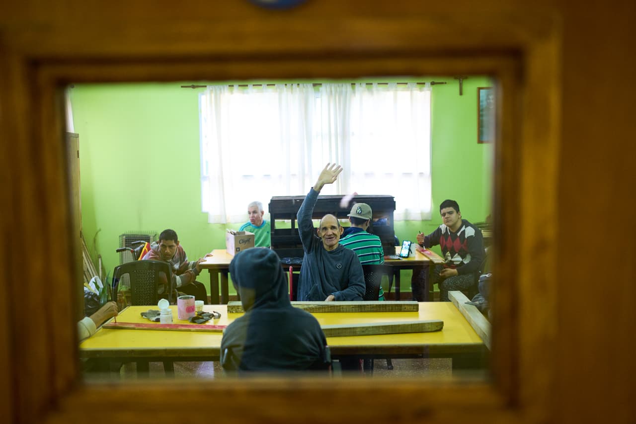 Un residente aplaude mientras asiste a una clase de carpintería en el Pequeño Cottolengo Don Orione.