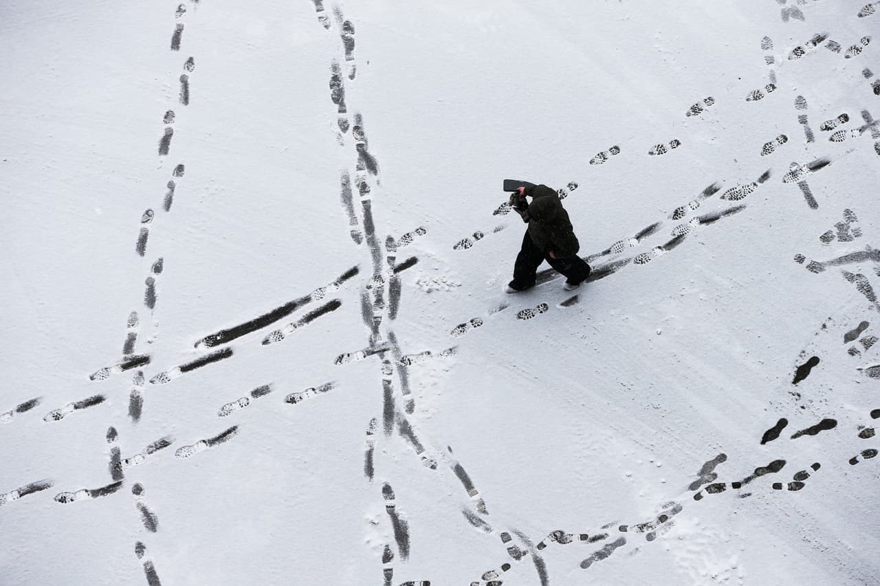 Un hombre deja sus huellas sobre la nieve en Green Bay, Wis.