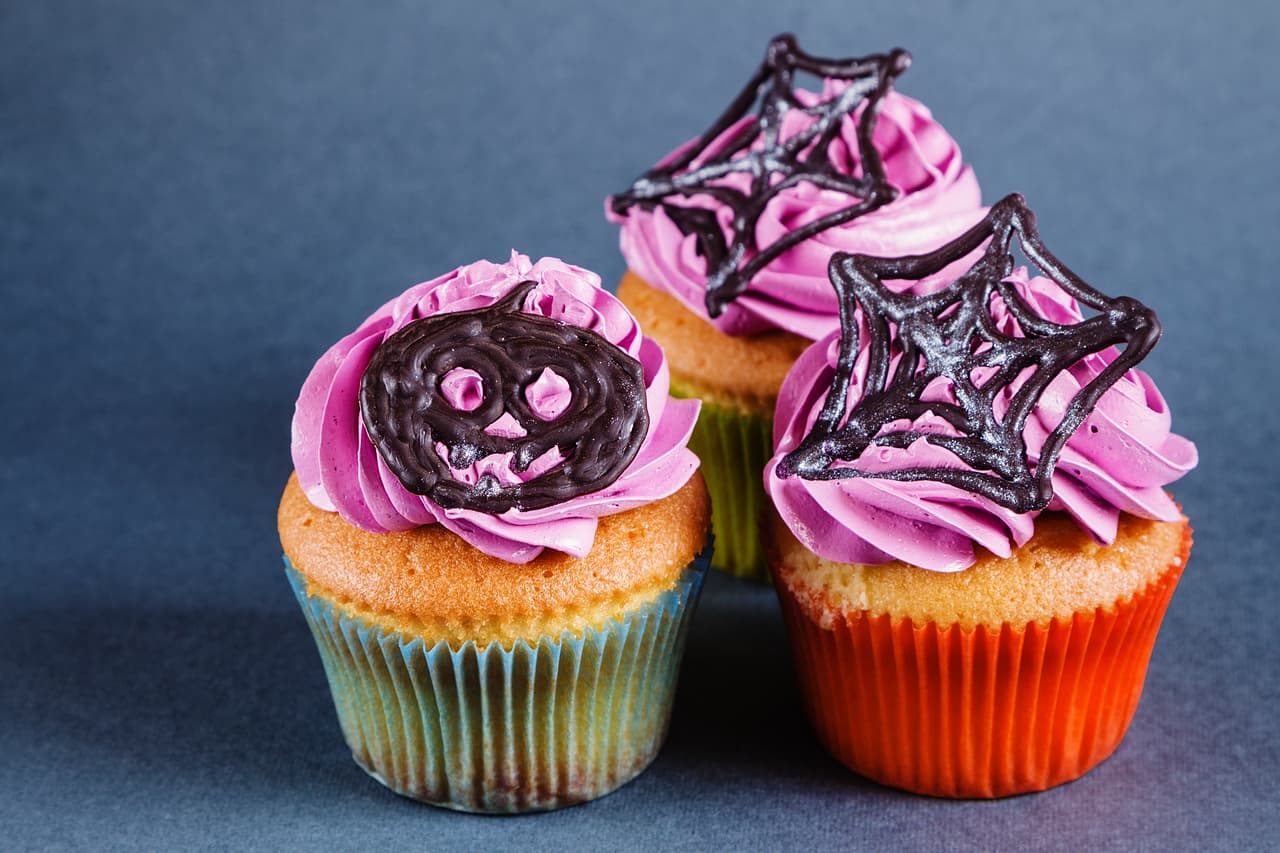 Puedes hacer un frosting de queso crema y agregarle colorante morado. Este color es uno de los que más caracterizan al Halloween, pero con chocolate se verá y sabrá mejor. Sólo forma figuras con chocolate caliente del que se usa para coberturas sobre una superficie previamente engrasada. espera a que el chocolate se endurezca y pon las figuras con cuidado sobre los cupcakes.