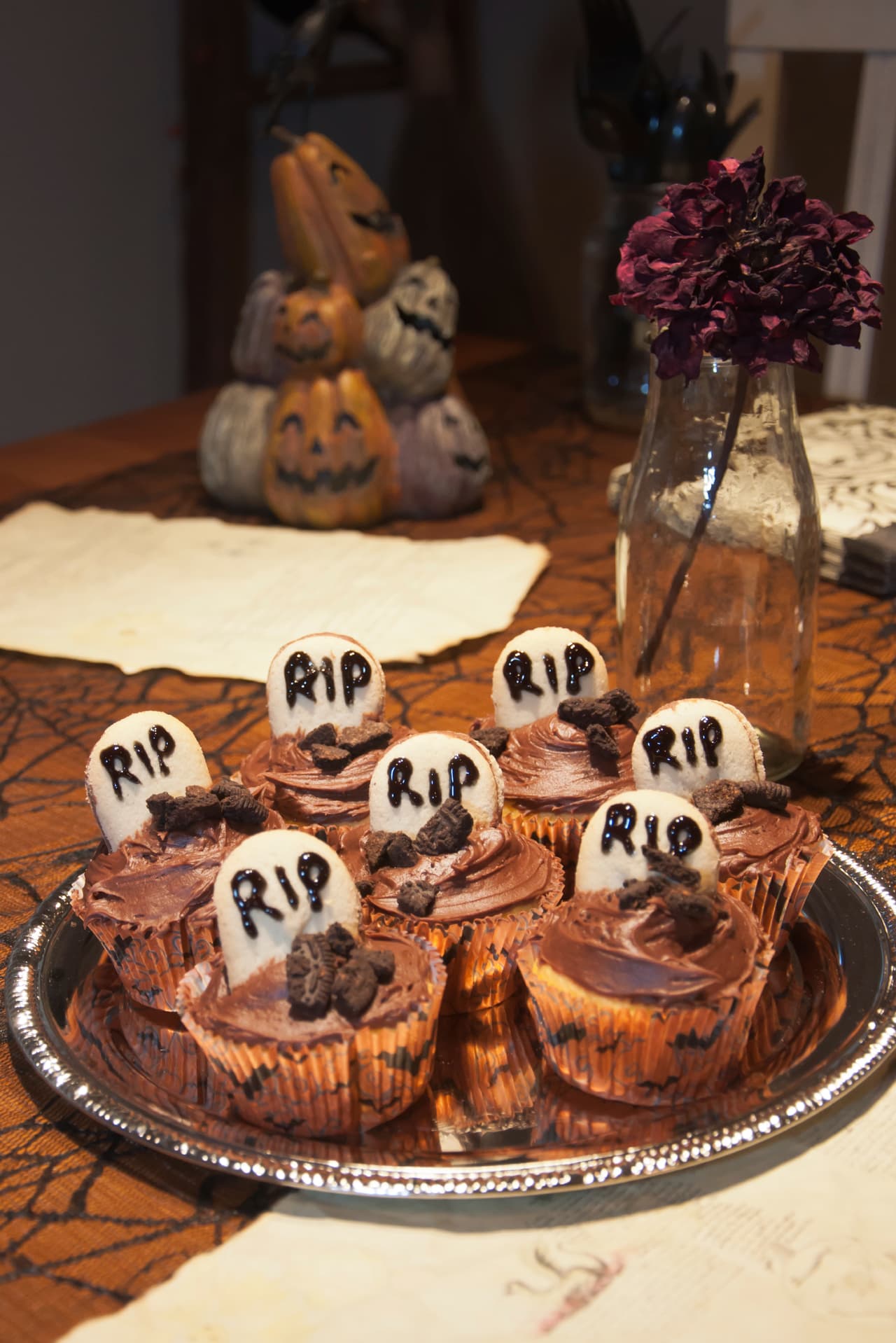 Estás criptas son deliciosas, solo pon un frosting de chocolate no tan abundante y una placa blanca de fondant, escribe las letras con chocolate y agrega trozos de galleta oreo. ¡Riquísimos!