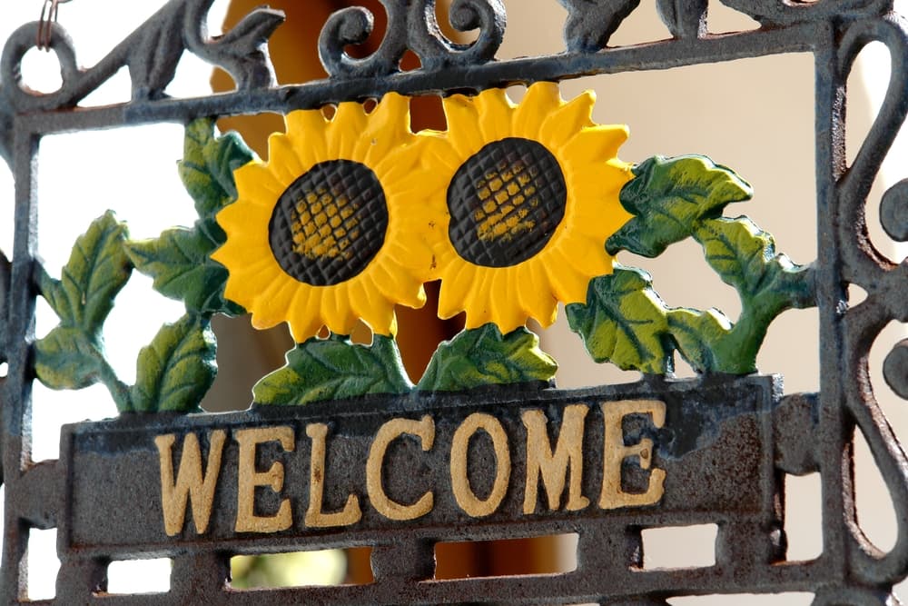 Así que ten por tu casa siempre un girasol, y puedes hacerlo también en otros detalles, como este letrero de bienvenida que incorpora la flor.