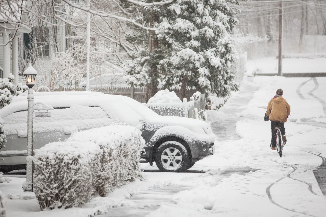 Landon Cluff trata de hacer girar las llantas de una bicicleta llena de nieve en Massachusetts.