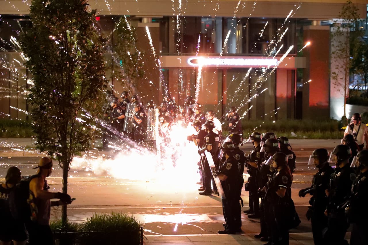 Fuegos artificiales explotaron entre las líneas policiales, arrojados por los manifestantes, que se concentraban cerca de la Casa Blanca, por segunda noche consecutiva.
