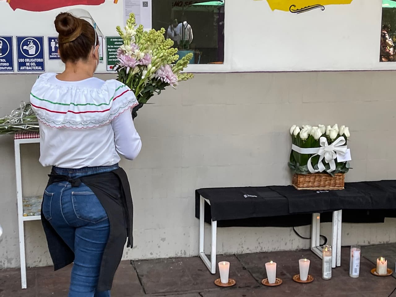 "Hay investigaciones que apuntan a que quisieron robarles la mercancía que ellos estaban ofreciendo en venta. Al parecer fueron despojados de la misma, de unas botellas de alto valor comercial", dijo Omar García Harfuch, secretario de Seguridad de la capital.
<br>En la imagen, una empleada del restaurante pone flores en el altar.