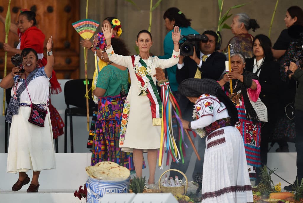 Claudia Sheinbaum (en el centro de la foto), en una ceremonia en la que recibe un bastón ceremonial de manos de indígenas en la Plaza del Zócalo de la Ciudad de México el 1 de octubre de 2024.
<a href="https://www.univision.com/noticias/america-latina/violencia-en-mexico-masacres-culiacan-sinaloa-sangre-el-inicio-del-mandato-de-claudia-sheinbaum">Sheinbaum marcó la historia como la primera mujer presidenta del país,</a> sucesora de su mentor político Andrés Manuel López Obrador.