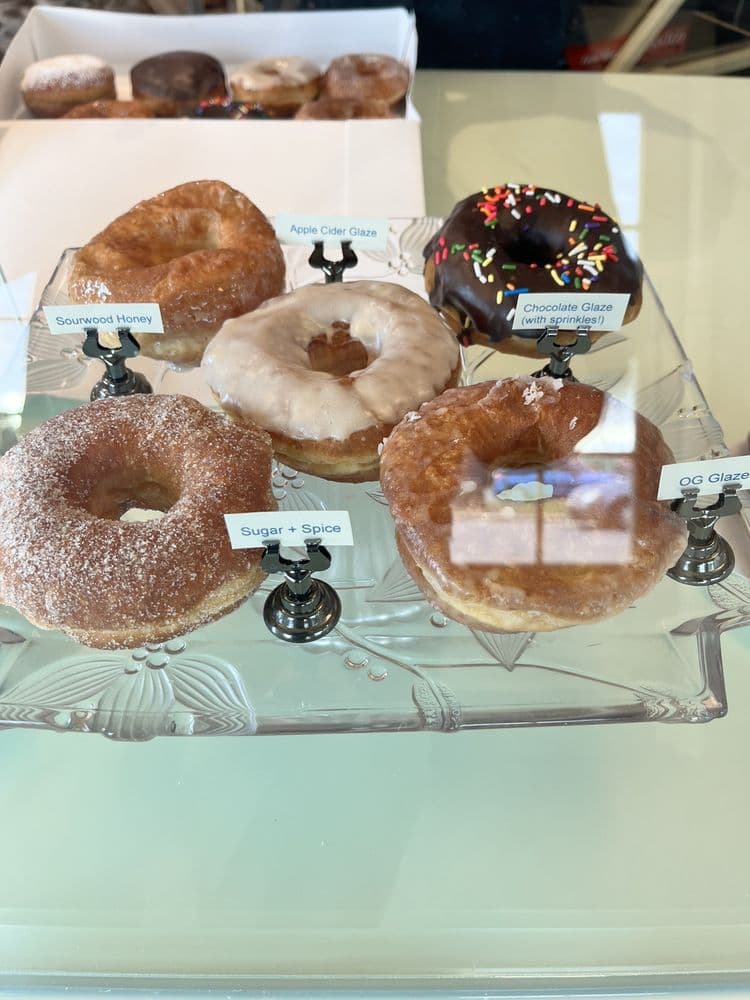 <b>Bright Spot Donuts </b>
<br>Dirección: 1501 Sunrise Ave Raleigh, NC 27608
<br>Sitio web: 
<a href="http://brightspotdonuts.com">http://brightspotdonuts.com</a> 
<br>
<b><a href="https://www.yelp.com/map/bright-spot-donuts-raleigh">Cómo llegar</a></b>
<br>
<br>Una usuaria de Yelp dijo que son “las mejores donas de la historia. Finalmente tuve la oportunidad de pasar y las donas no me decepcionaron. Prefiero mucho la levadura como las donas, así que estas donas eran justo lo que estaba buscando. Son ligeras, aireadas y con mucho sabor”.
