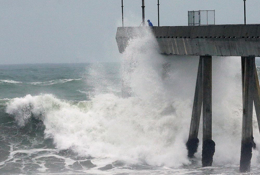 La fuerza del viento hace golpear las olas contra un muelle en Pacifica.