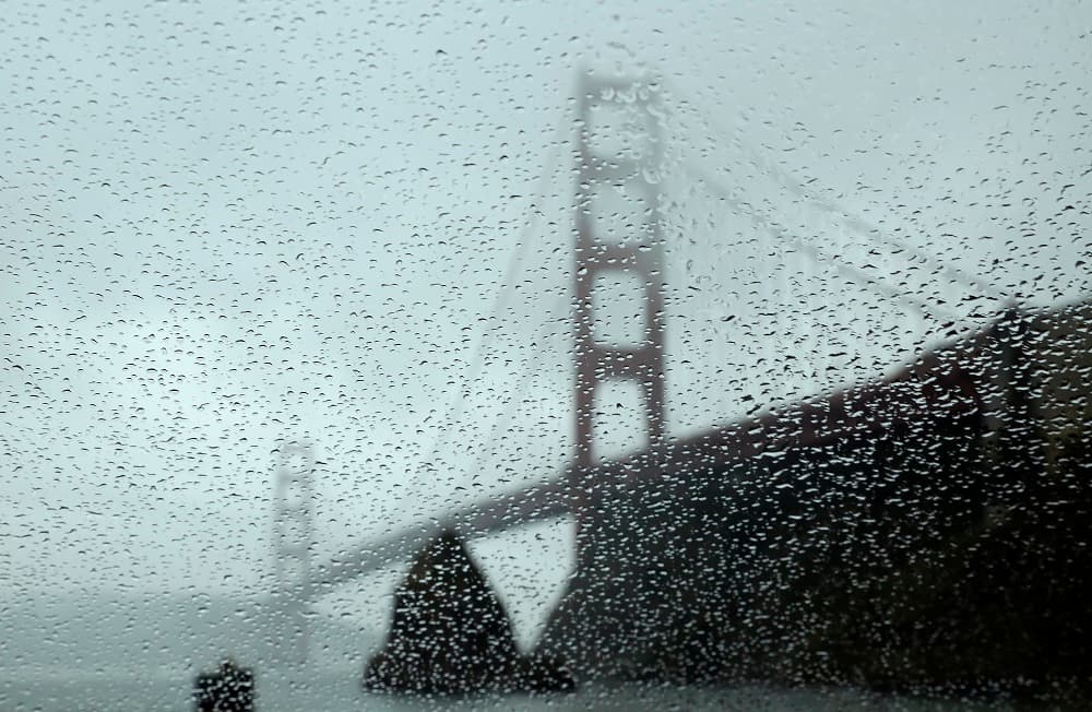 El icónico puente de San Francisco, tras los cristales mojados de un carro.