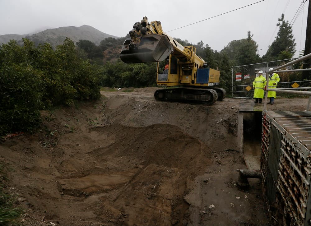 Autoridades inspeccionan en Azusa un agujero ante las consecuencias por las lluvias.