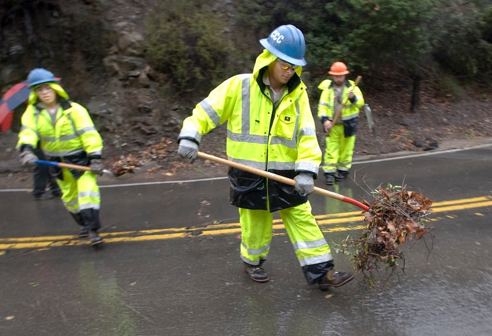Operarios limpian lo que el agua ha arrastrado a las carreteras en Silverado