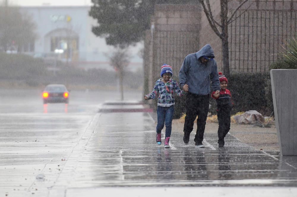 Varias personas bajo la fuerte lluvia que cayó en Victorville.