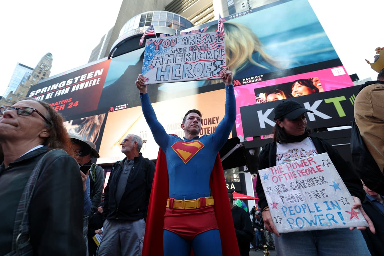 Este manifestante, vestido como los típicos superhéroes que reciben a diario a los 
<b>turistas en Times Square</b>, protesta en 'No Kings' con un mensaje que dice: 
<b>"Todos ustedes son los superhéroes americanos reales".</b>