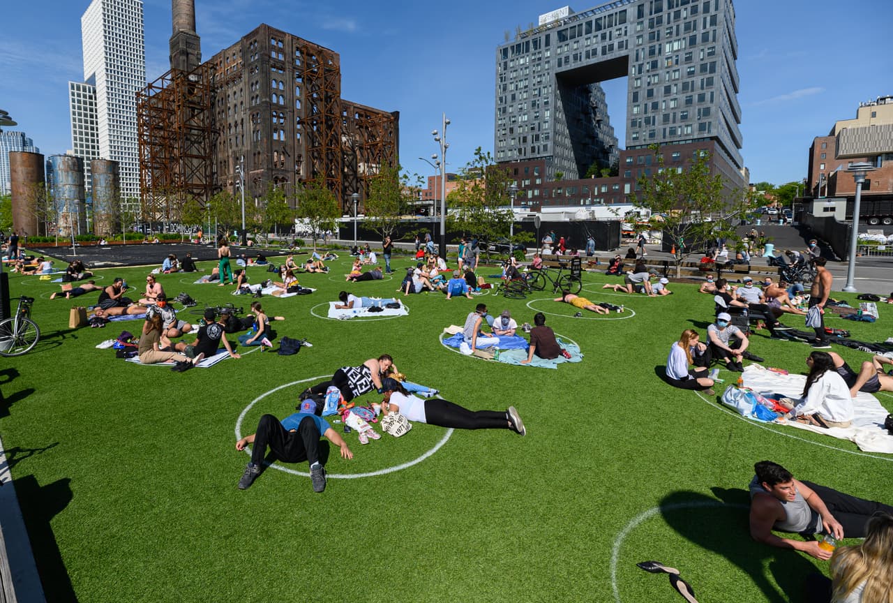 En el parque Domino, de Brooklyn, Nueva York, las autoridades dibujaron círculos que indican los espacios que pueden ser ocupados por los visitantes, lo que mantiene la distancia entre los grupos. 17 de mayo. 
<br>