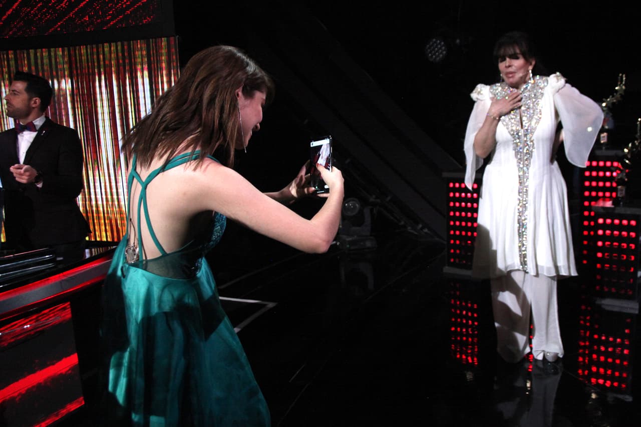 Se sintió tan cómoda con su vestido que se levantaba de su asiento durante cada corte comercial, esto para platicar con sus compañeros y tomarles fotos.