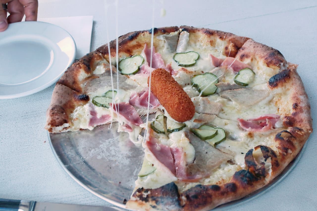 Los creadores de esta receta piensan que la “Cubano Pizza’ va a unir la comunidad de Miami o a dos hambrientos comensales que se disputen la croqueta, que adorna el centro de la pizza.