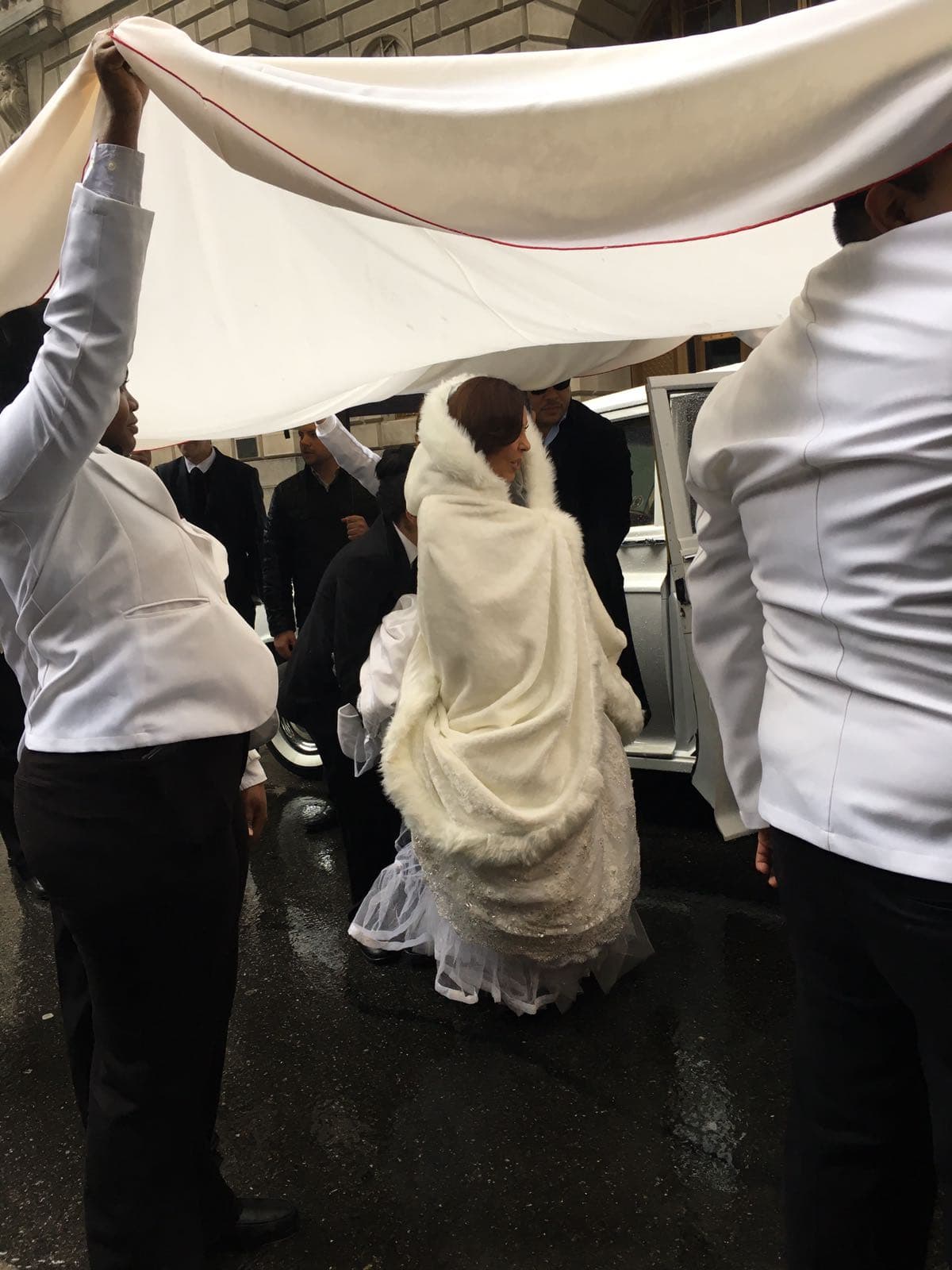 Gelena se tapó con una capa para evitar que su vestido se estropeara en el breve recorrido que iba desde el estacionamiento hasta el interior del restaurante.