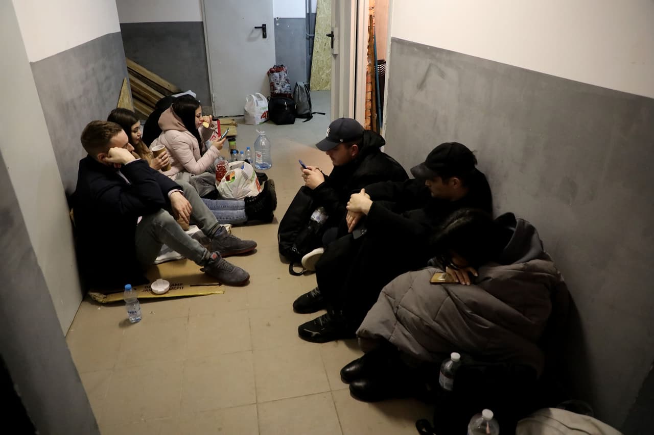 Residentes esperan sentados en el suelo del sótano de un edificio residencial de Kiev, una ciudad que tiene cinco días recibiendo ataques de cohetes rusos. 25 de febrero.
<br>