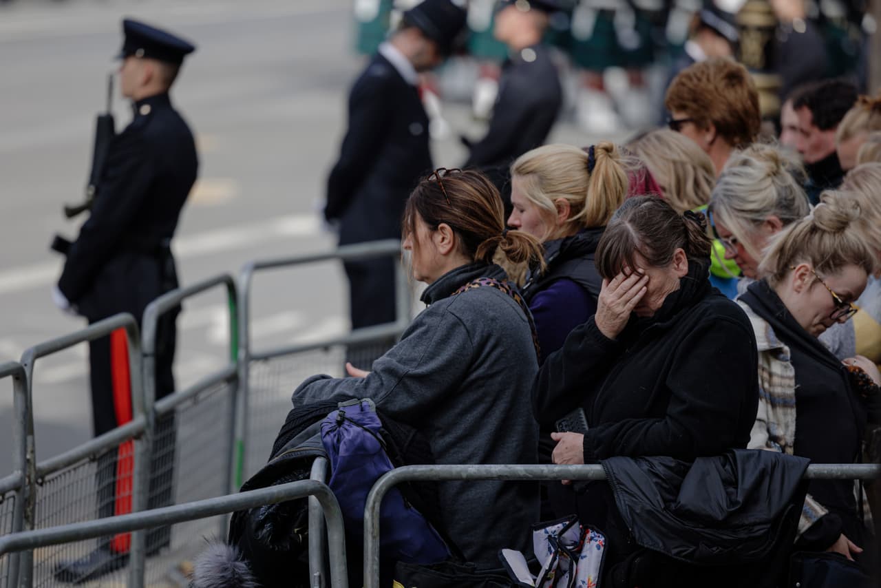 Cientos de personas se ubicaron en el camino por el que la reina sería trasladada al castillo de Windsor. En la imagen, un grupo de mujeres rinden respeto a la monarca mientras la procesión avanza.