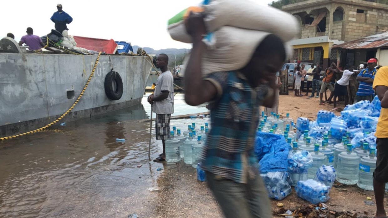 Un hombre lleva bolsas de arroz que Food for the Poor transportó a Pestel por medio de barcazas el jueves junto con otras mercancías de ayuda.