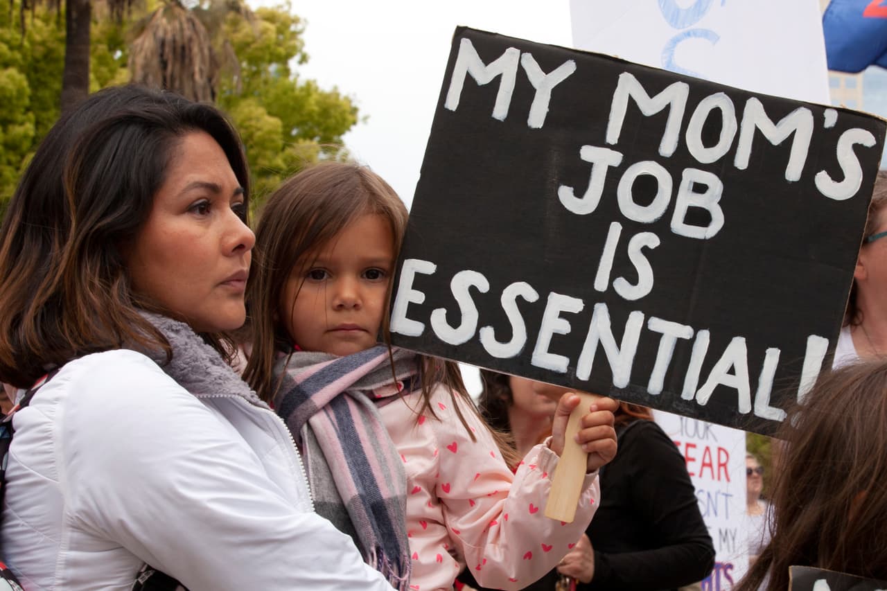 "El trabajo de mi mamá es esencial", dice el mensaje de la niña Sophie en brazos de su mamá Georgina Orante. El argumento de muchos de los manifestantes es que la economía es esencial, y que los esfuerzos para contener el coronavirus causan más daño a la economía con cada día del cierre estatal. Orante dijo que es dueña de un salón de belleza que podría cerrar para siempre si ella no puede regresar a trabajar. (AP/Rich Pedroncelli)