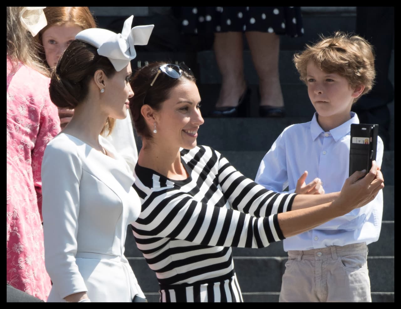 Para cumplir con el protocolo, la protagonista de la cinta 'Mr. & Mrs. Smith' utilizó un tocado con moño alto, que hizo juego con unos guantes de seda y que completó con un bolso clutch en plateado.