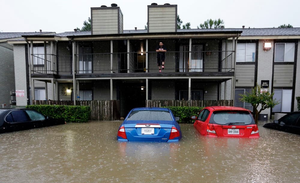 Un residente de Houston mira desde el segundo piso el parqueo inundado de su edificio.