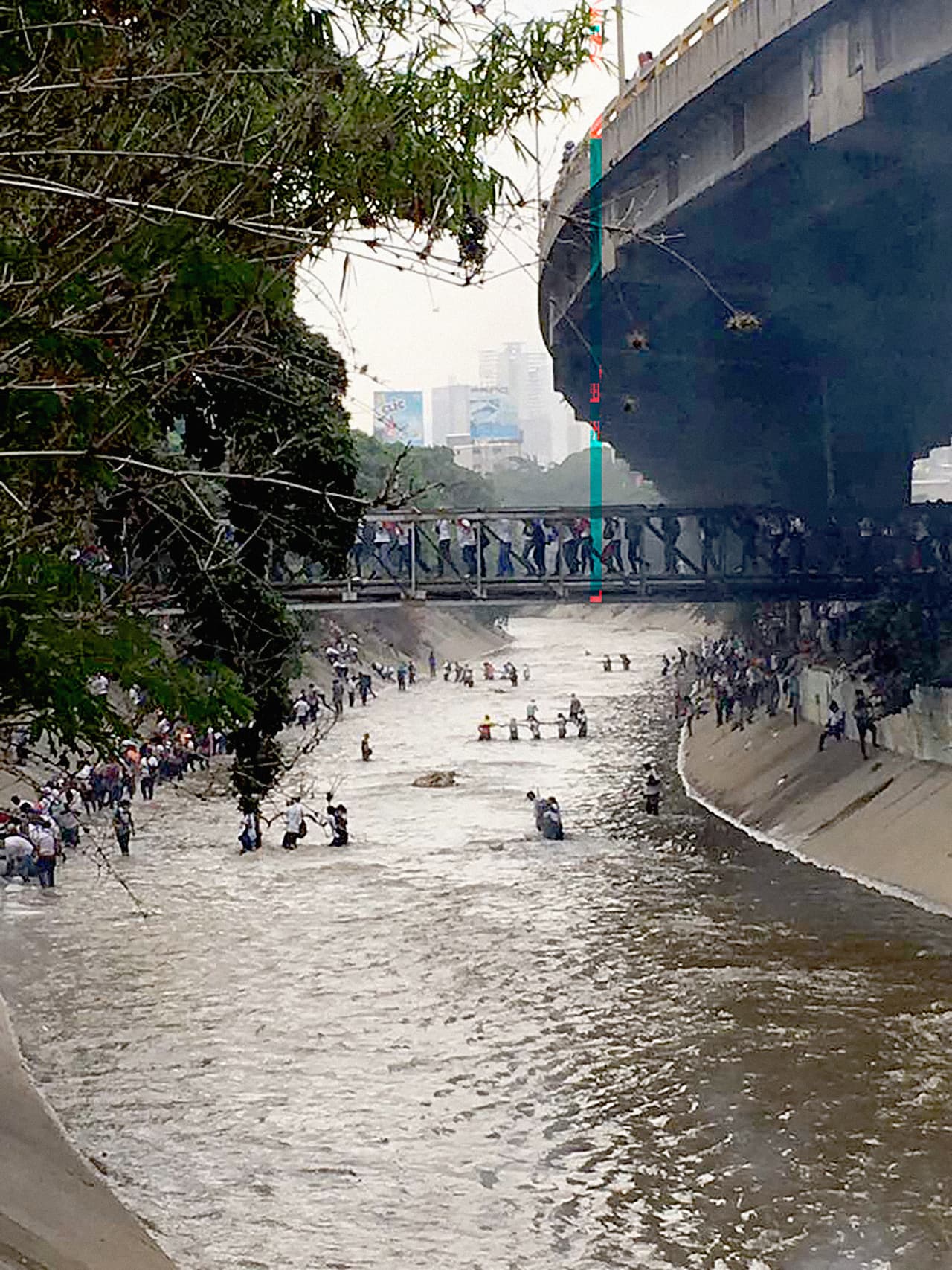 Some demonstrators managed to cross the river using pipes as a bridge, others waded through the sewage-filled waters.