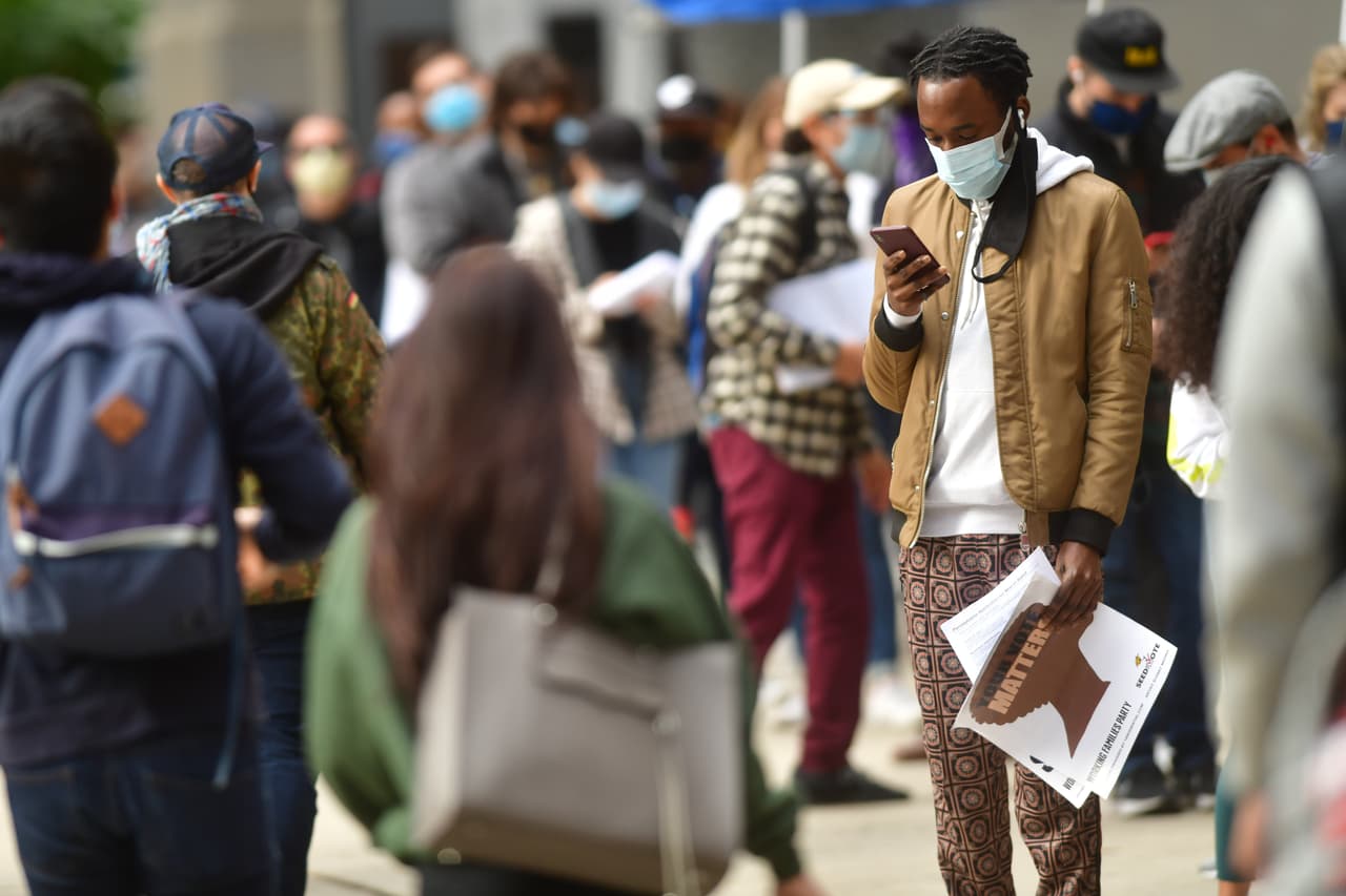 Los votantes esperan en fila afuera del Ayuntamiento de Filadelfia el último día para emitir sus boletas de votación.