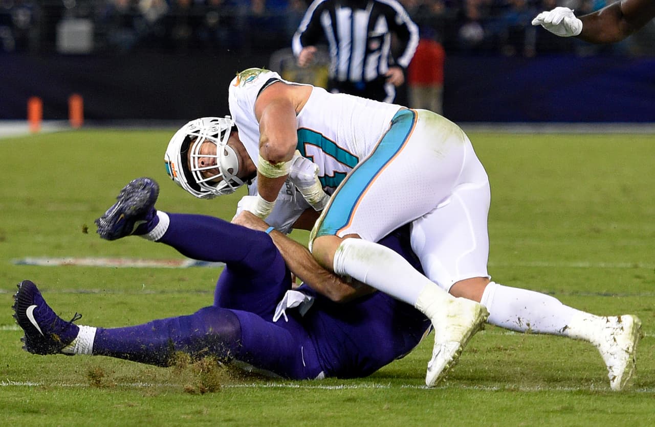 Miami Dolphins middle linebacker Kiko Alonso, top, collides with Baltimore Ravens quarterback Joe Flacco as Flacco slides on the field after rushing the ball in the first half of an NFL football game, Thursday, Oct. 26, 2017, in Baltimore. (AP Photo/Nick Wass)